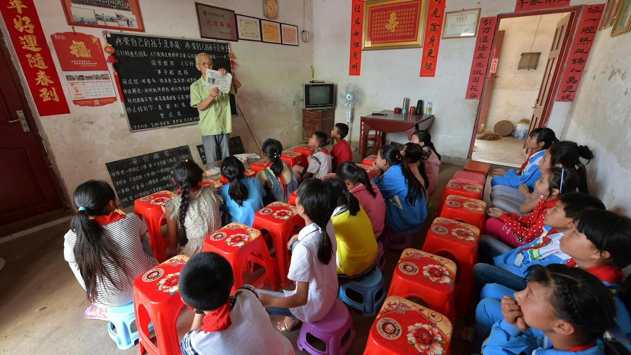 Children attentively listening to a teacher in a rural classroom setting in Jiangxi, China.