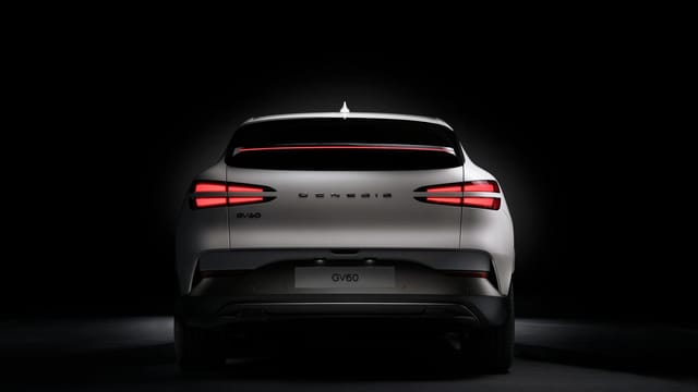 Rear view of a white Genesis GV60 electric car showcasing its distinctive rear lamp design.