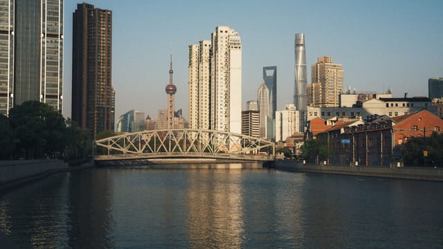 Stunning view of Shanghai's skyline featuring famous landmarks and Waibaidu Bridge during sunset.