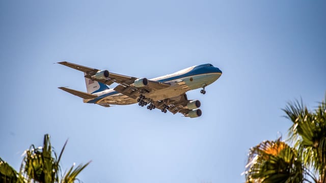 Presidential aircraft Air Force One flying above palm trees in Palm Springs, California.