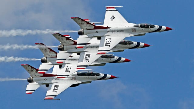 USAF Thunderbirds in precise aerial formation during airshow in Florida, showcasing skill and precision of fighter jets in clear skies.