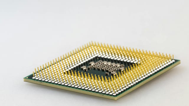 A detailed close-up of a CPU microchip showcasing its intricate gold pins and technology.