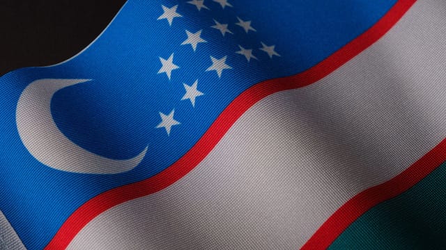 A close-up of Uzbekistan's flag, featuring a crescent and stars, symbolizing national pride.