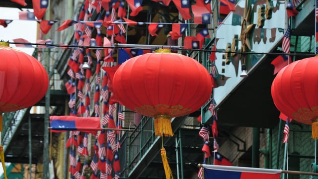 Vibrant red lanterns with flags in San Francisco's Chinatown, showcasing a cultural celebration.