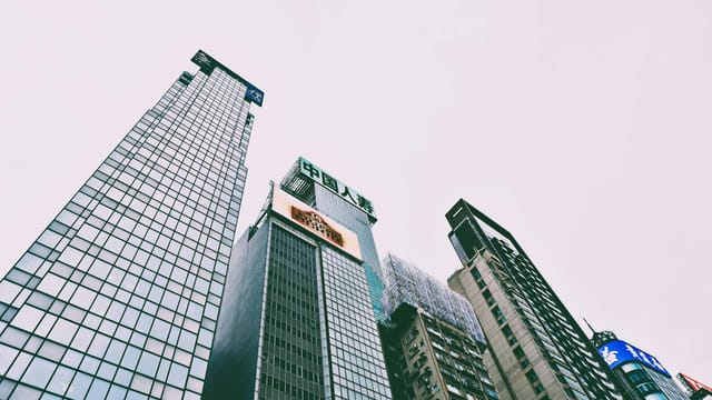 Low-angle view of skyscrapers in Hong Kong with overcast sky.
