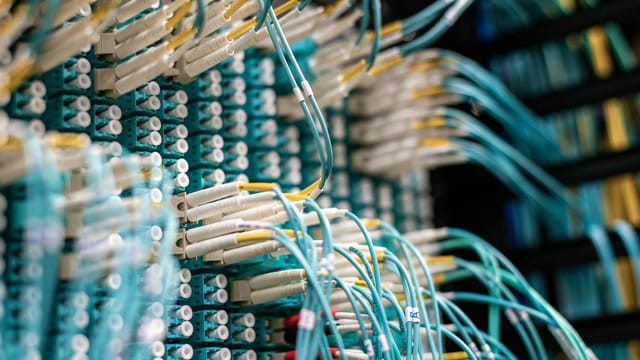 Detailed view of fiber optic cables connected to a patch panel in a data center.