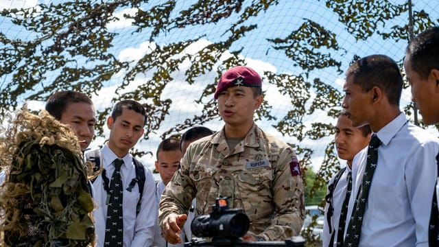 A military leader instructing young cadets outdoors in Aldershot, England.