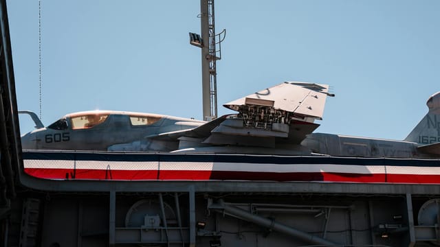 Close-up of a military aircraft on display against a clear blue sky in San Diego, CA.