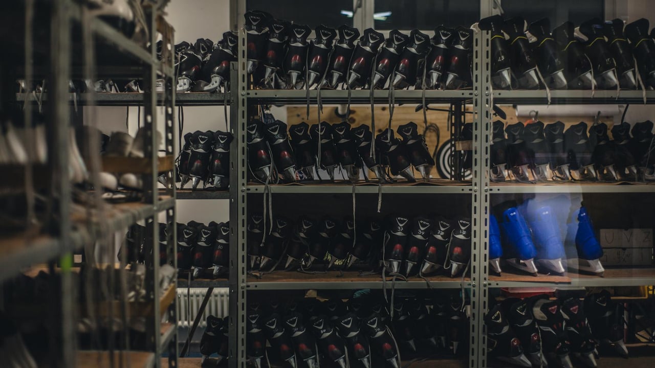 Neatly organized skate boots on shelves in an indoor shop setting, ready for sale.