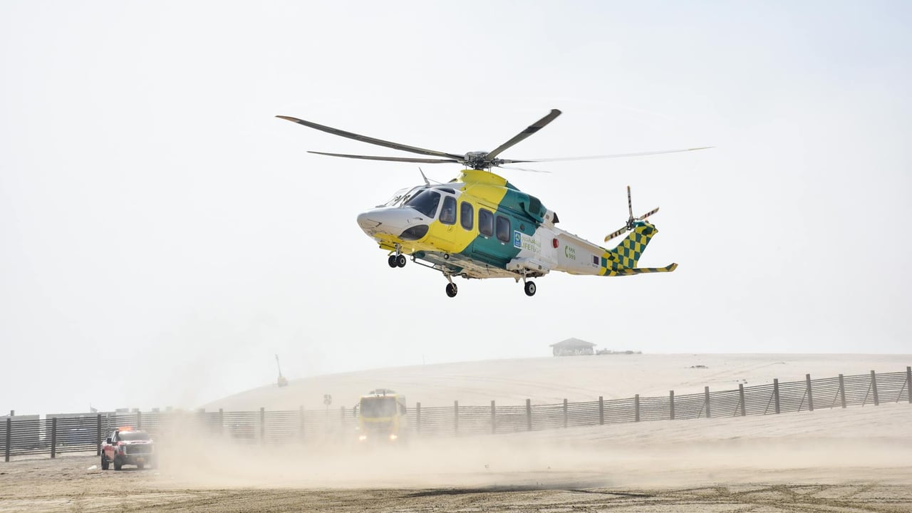 A medical helicopter hovers above the sandy desert in Doha, Qatar, ready for urgent transport.