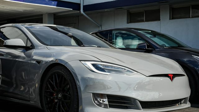 Close-up view of a sleek Tesla Model S parked outdoors, showcasing modern electric vehicle design.