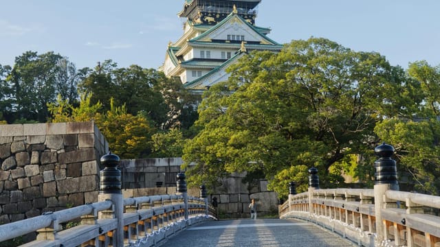 Beautiful view of Osaka Castle with a traditional Japanese bridge in the foreground.