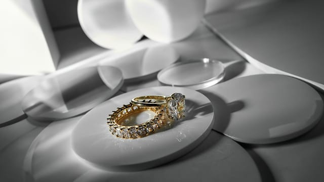 Close-up of elegant gold and diamond rings on a modern abstract surface, showcasing luxury style.