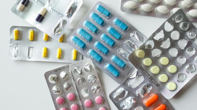 Colorful assortment of pills and capsules in blister packs for healthcare and medication usage.