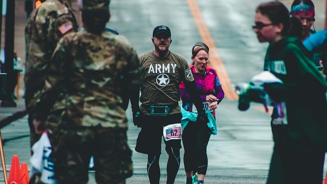 Military and civilians competing in a street race, showcasing teamwork and endurance.