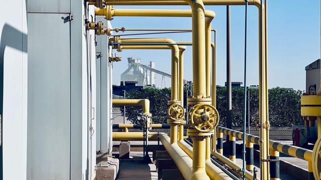 A detailed view of industrial pipelines in a Saudi Arabian factory setting.