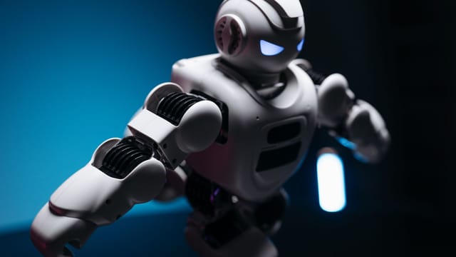 Dynamic shot of a futuristic robot with glowing eyes in a dark studio, showcasing innovation.