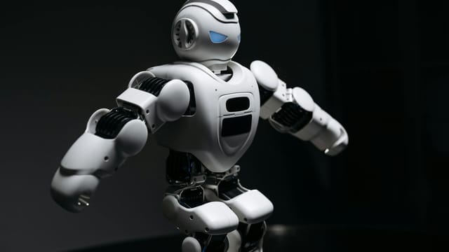 Close-up of a futuristic humanoid robot under dramatic lighting in dark ambiance.