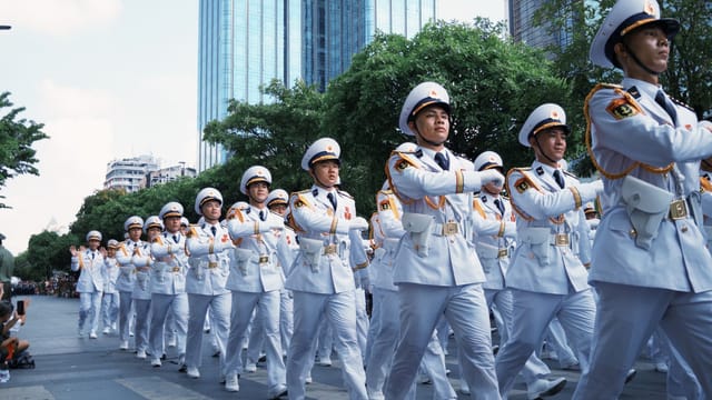 Group of uniformed officers marching in a city parade.