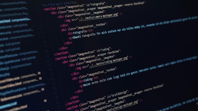 Close-up view of HTML code displayed on a dark screen, showcasing coding concepts.