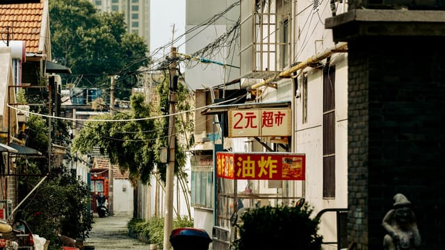 A peaceful alley with traditional Chinese signs, showcasing local culture and architecture.