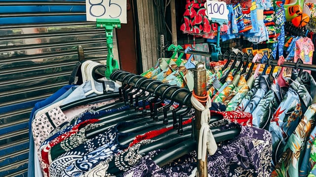Colorful shirts on display at a street market, showcasing unique patterns and vibrant styles.