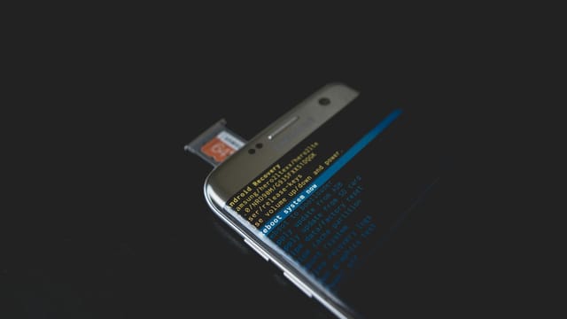 Close-up of a smartphone displaying Android recovery mode with an SD card inserted.