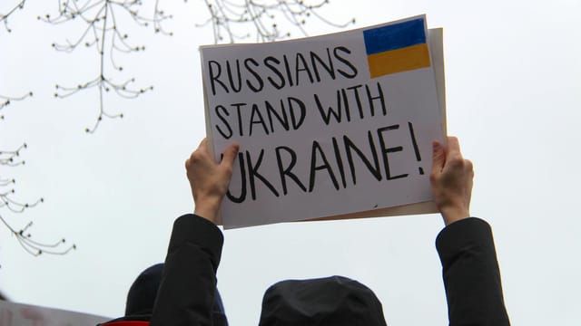 Protesters in Vancouver hold signs supporting Ukraine against Russian actions.