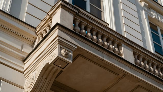 Low-angle view of a classical building facade showcasing intricate architectural details.