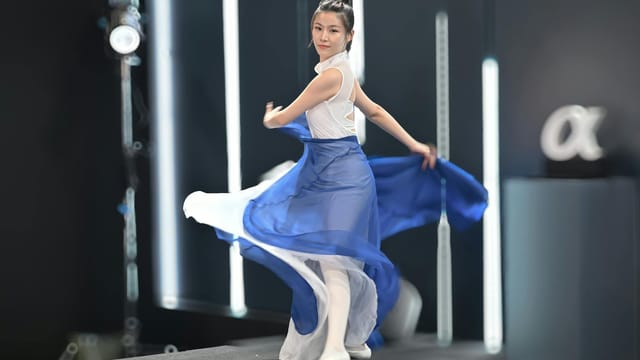 A graceful dancer in a white and blue costume twirling on stage, Taipei, Taiwan.