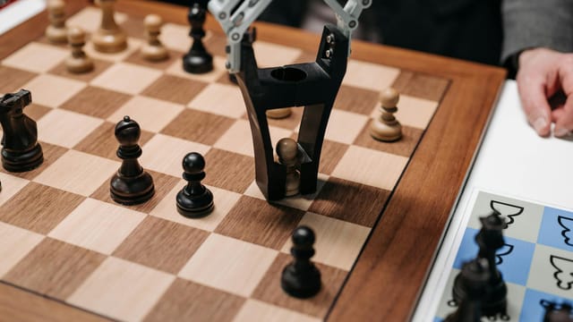 Robotic arm playing a strategic chess game on a wooden board, showcasing technology and innovation.