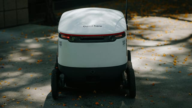 Autonomous delivery robot in urban setting, showcasing modern technology.