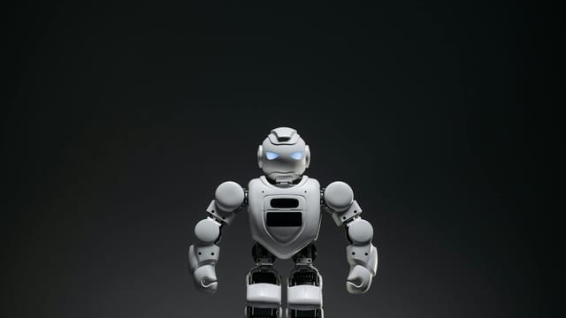Close-up of a white toy robot with glowing eyes in a studio setting.