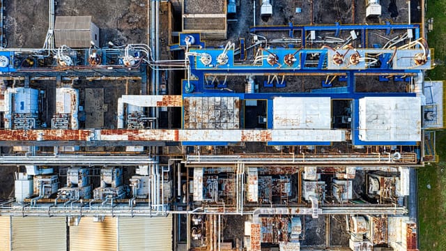 Illustrative image: Aerial view of modern industrial factory with buildings and various special equipments in daytime