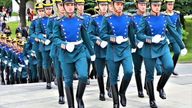 A group of soldiers in traditional uniforms marching during a parade in Moscow.