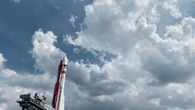 Vostok rocket displayed against a vibrant cloudy sky, showcasing engineering and space exploration.