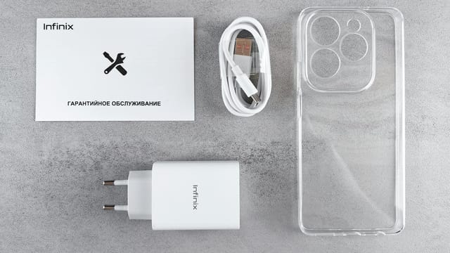 Flat lay of Infinix smartphone accessories with charger, cable, case, and warranty card.