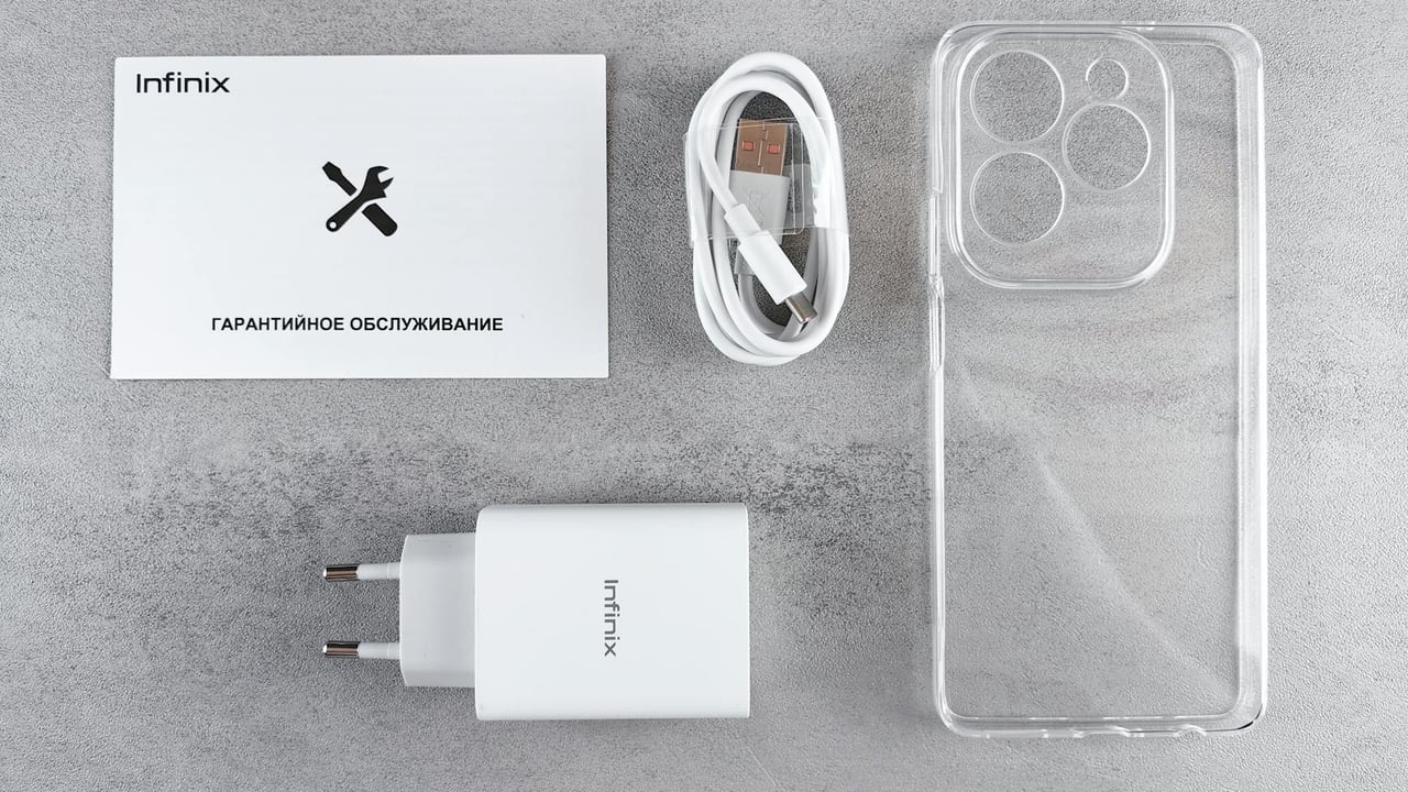 Flat lay of Infinix smartphone accessories with charger, cable, case, and warranty card.