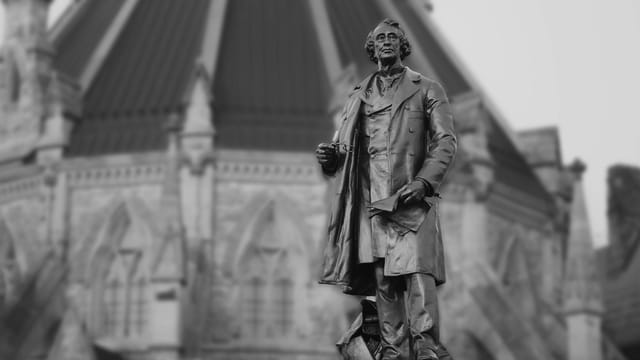 A black and white photo of the John A. Macdonald statue in Ottawa, Canada.