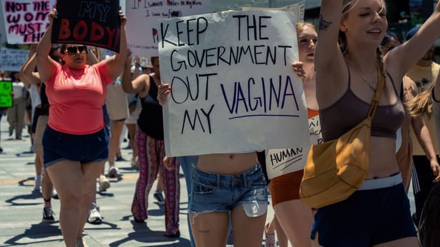A vibrant protest advocating for women's rights with bold placards and passionate individuals.