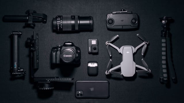 Aerial view of various photography and drone gadgets on a black surface.