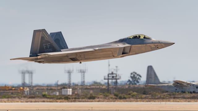 An F-22 Raptor jet fighter captured soaring above San Diego during an airshow.