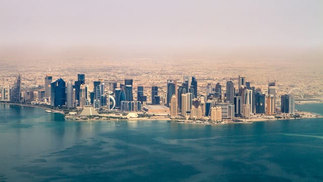 Stunning aerial view of the Doha skyline under a clear sky, showcasing modern architecture in Qatar.
