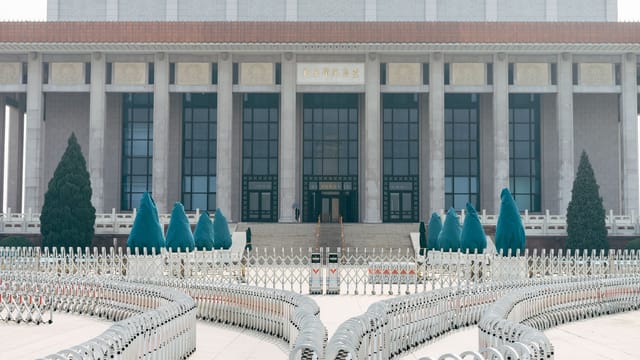 View of the historic building with grand columns and security barriers in an urban setting.