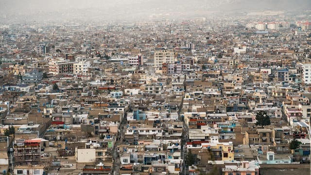 Expansive aerial view of Kabul city, showcasing urban density and surrounding mountains in Afghanistan.
