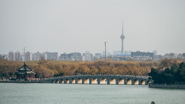 Scenic view of Seventeen Arch Bridge in Beijing with city skyline.