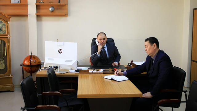 Two businessmen engaged in a planning meeting in a corporate office setting.