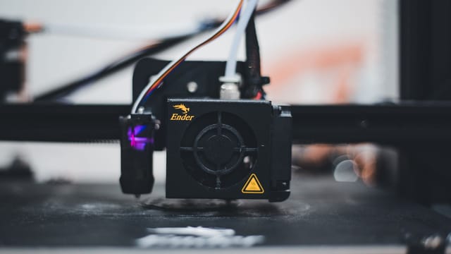 Detailed view of a 3D printer nozzle during the printing process, showcasing advanced technology.