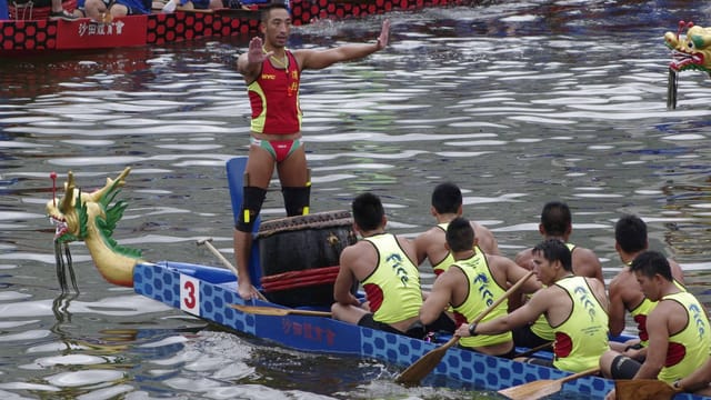 A team of paddlers competes in a vibrant dragon boat race in Hong Kong's New Territories.