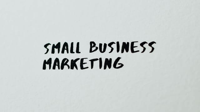 Text 'Small Business Marketing' written on white paper for creative use.